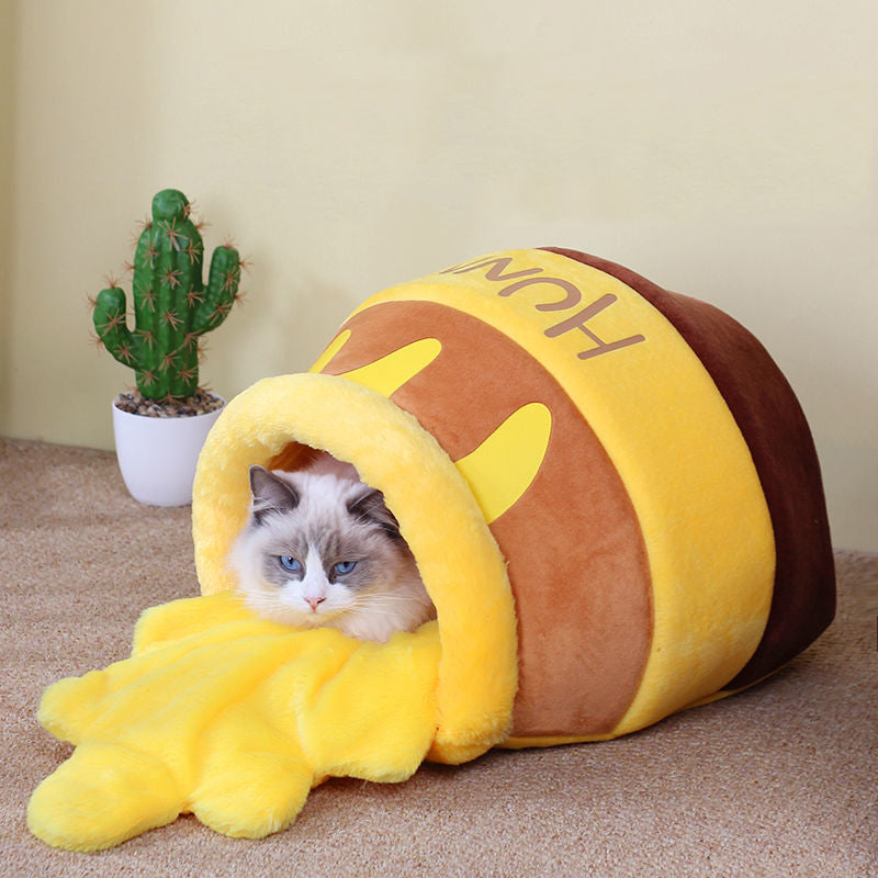 Chat confortable dans un lit en forme de pot de miel pour chat